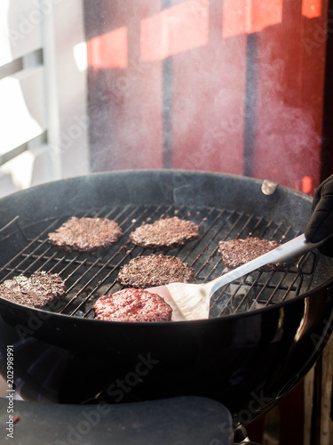 Flipping burgers on grill