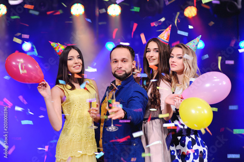 a guy and three girls rejoice and celebrate the party in the night club. Birthday, new year, corporate party, best friends