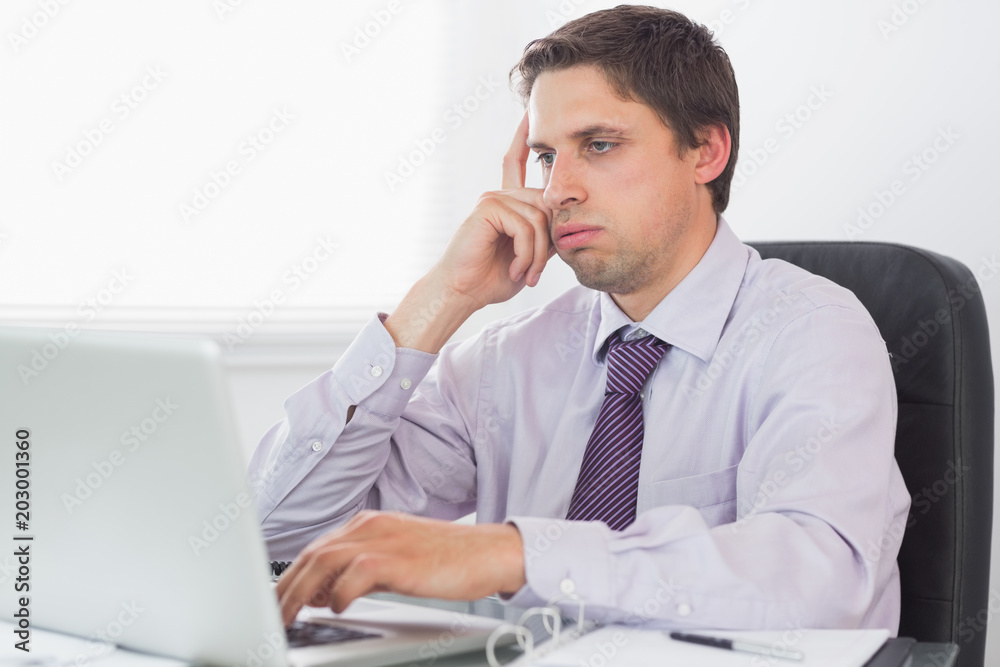 Worried businessman using laptop in office Worried businessman using laptop in office