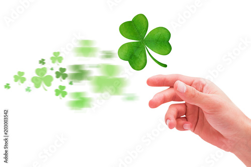 Shamrock against hand with raised fingers © vectorfusionart