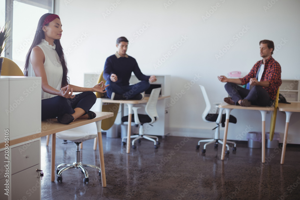 Business people practicing yoga at office