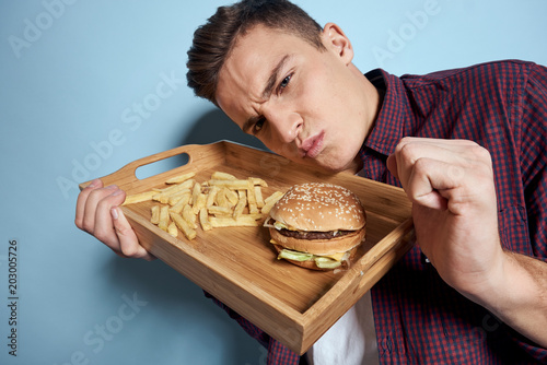 man put his face on a tray with fast food