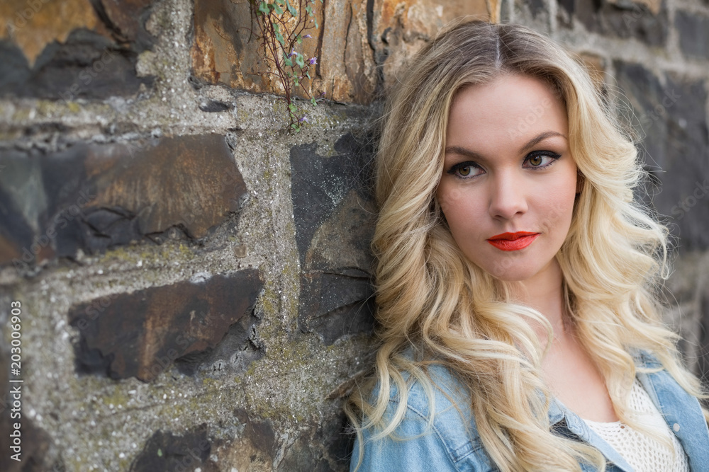 Peaceful blonde wearing denim clothes posing outdoors Peaceful blonde wearing denim clothes posing outdoors