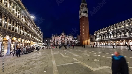 Piazza San Marco and Basilica of St Mark night timelapse. Cathedral church of Roman Catholic Archdiocese of Venice. Tourists walking in front of it. 4K photo