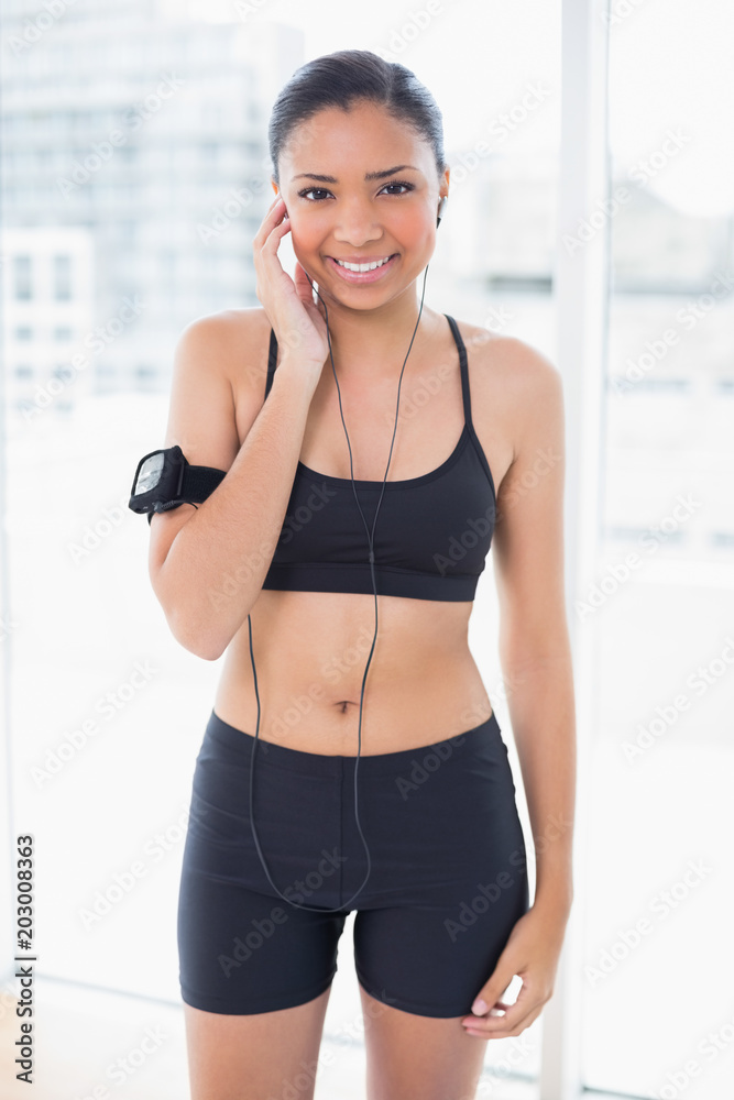 Delighted dark haired model in sportswear enjoying music