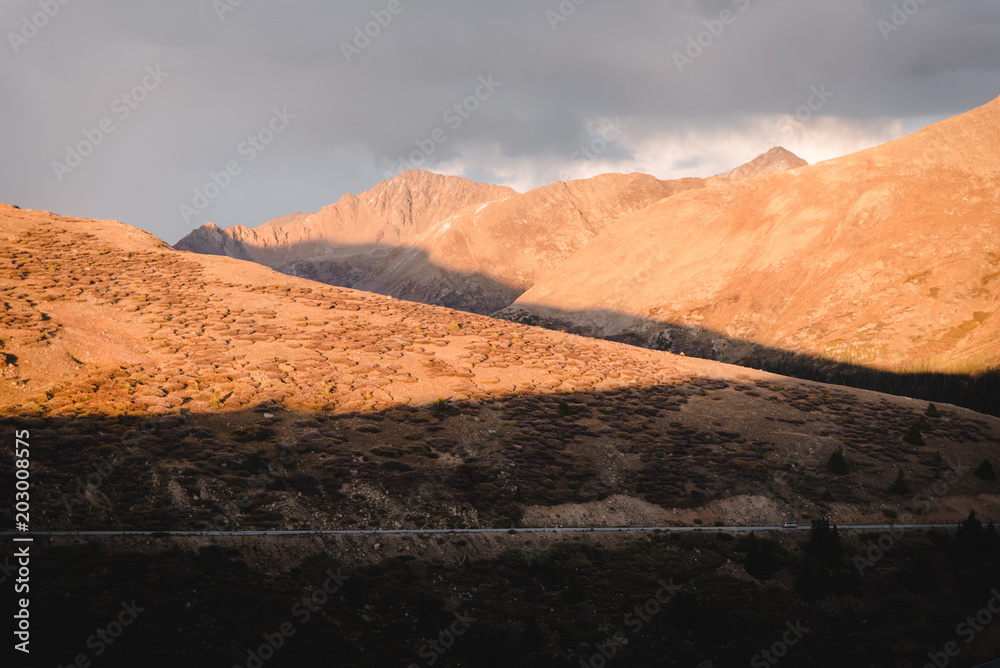 Naklejka premium A highway running through the mountains in Colorado during sunset. 