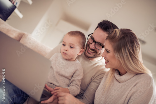 Young family watching cartoon on laptop together