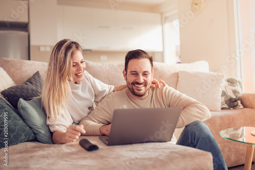 Happy couple using laptop