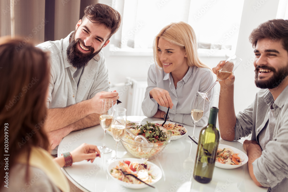 Positive happy young people enjoying food at home Positive happy young people enjoying food at home