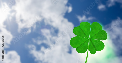 Shamrock against bright blue sky with clouds © vectorfusionart