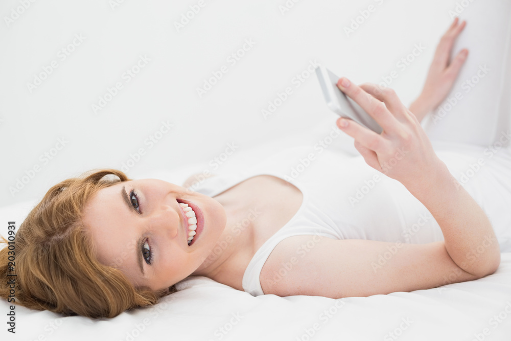 Portrait of relaxed woman with mobile phone in bed