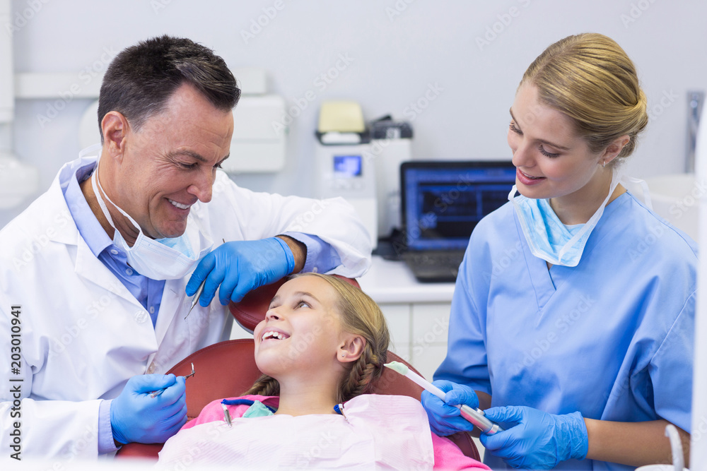 Dentist and nurse interacting with a young patient Dentist and nurse interacting with a young patient