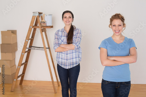 Friends standing with arms crossed in a new house