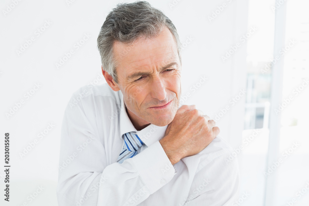 Closeup of a mature man suffering from shoulder pain Closeup of a mature man suffering from shoulder pain
