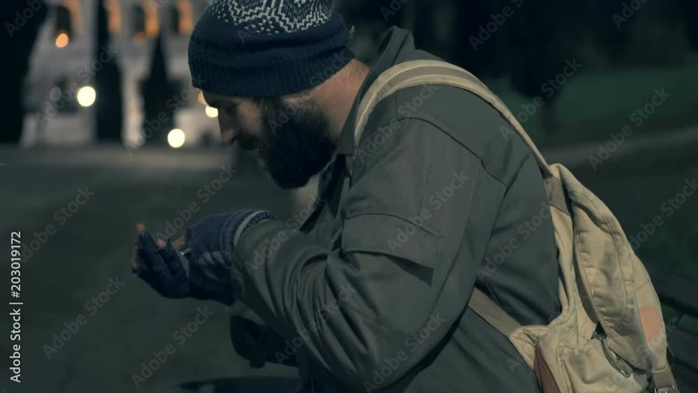 hungry Homeless on bench at night counting his coins hungry Homeless on bench at night counting his coins