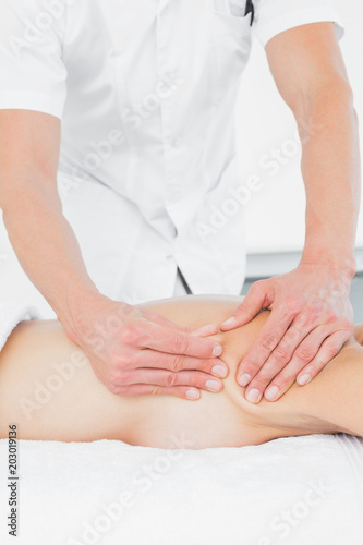 Mid section of a physiotherapist massaging womans body