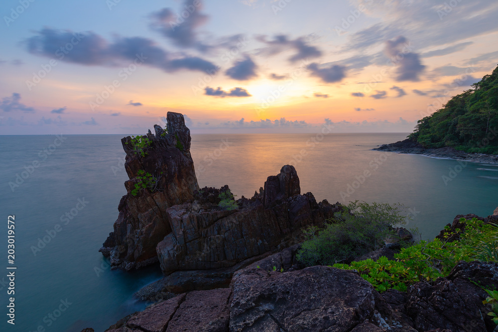 Large rocks and spiky filed in sea green waters and golden evening sky. Long Exposure Photography Technique .Chai Chet, Koh Chang, Trat, Thailand
