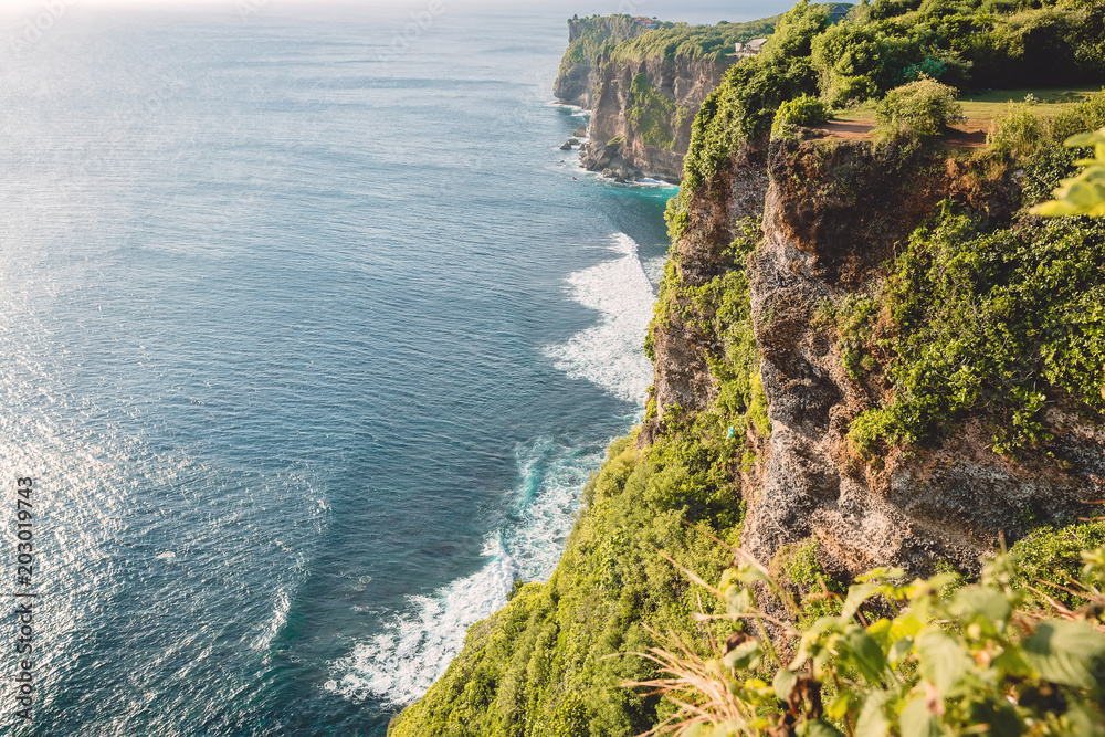 Indian ocean and rocks, cliff with trees in Uluwatu, Bali