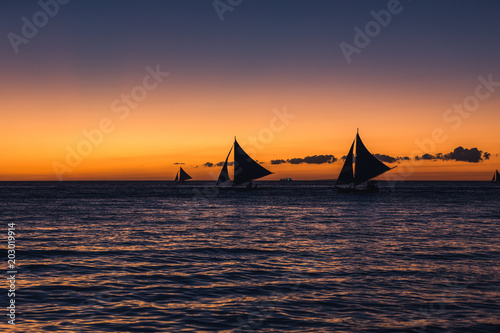 Many outrigger sailboats on the horizon