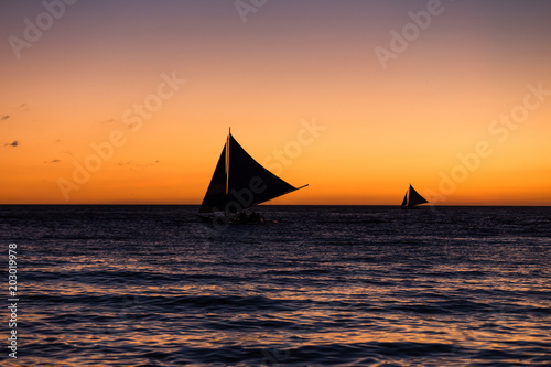 Two outrigger sailboat on the horizon