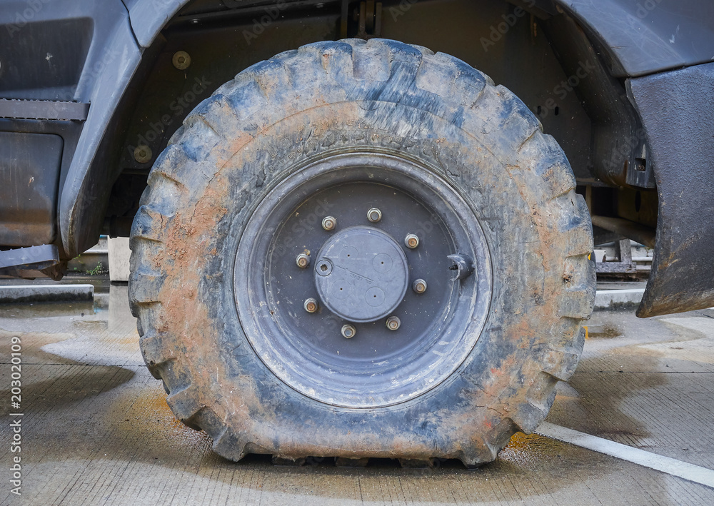 Deflated damaged tyre on truck wheel