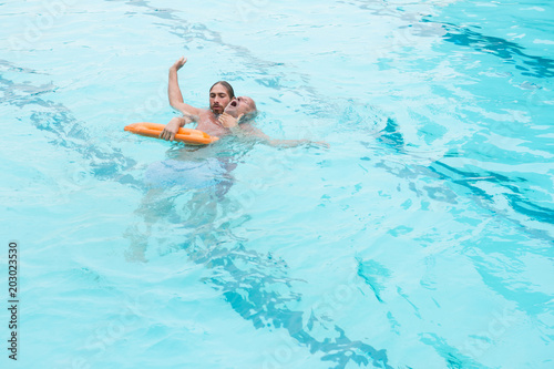 Lifeguard rescuing senior man from swimming pool