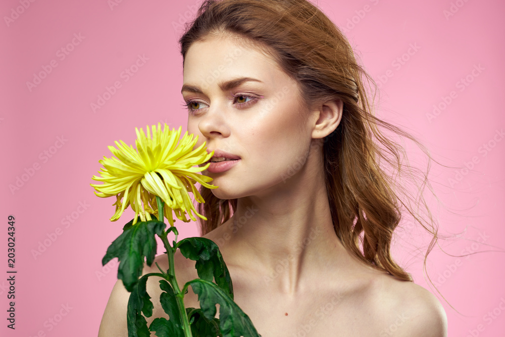 woman with a flower on a pink background