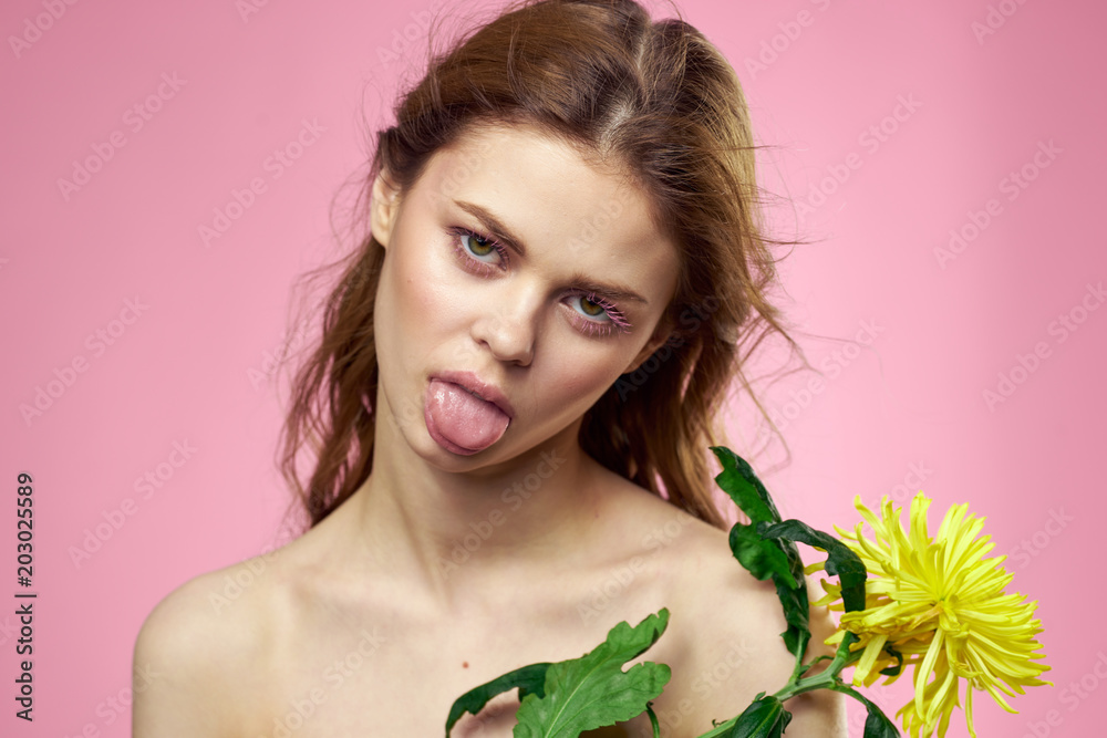 Fototapeta premium woman with a flower shows tongue