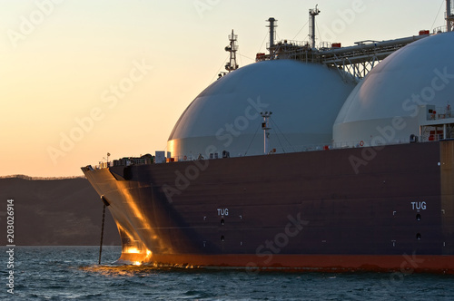 The bow of a huge LNG carrier at anchored in the roads.