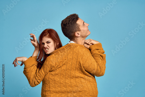 young couple in one sweater on a blue background