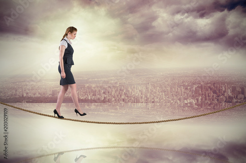 Redhead businesswoman stepping on tightrope against room with large window looking on city