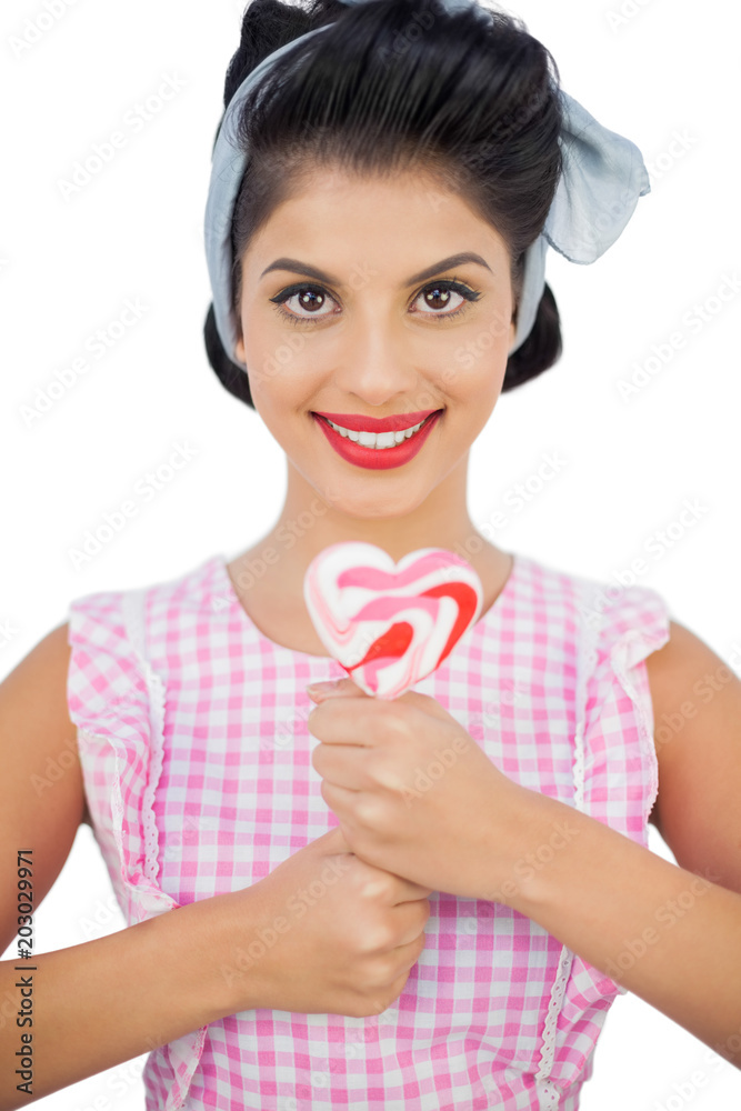 Cheerful black hair model holding a heart shaped lollipop Cheerful black hair model holding a heart shaped lollipop