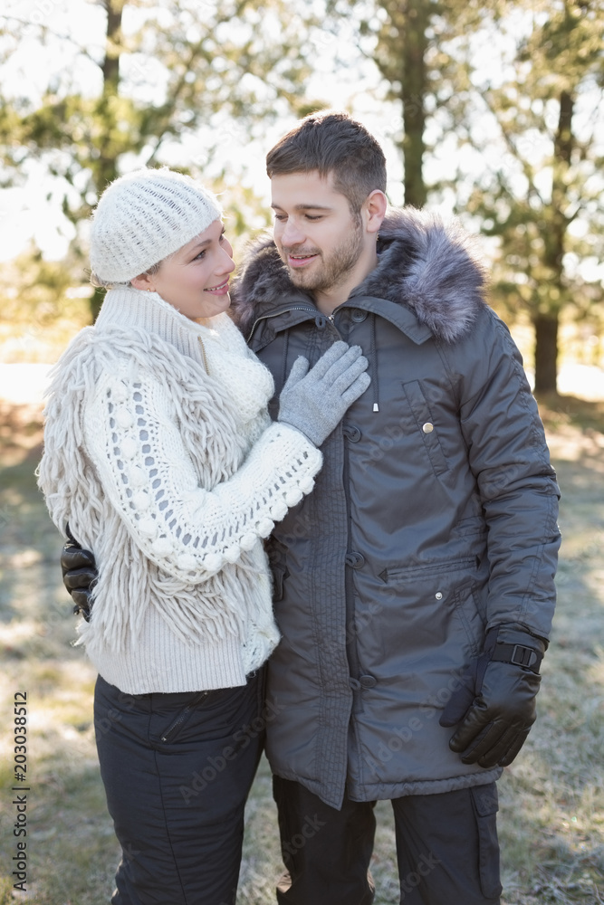 Loving couple in winter clothing in the woods