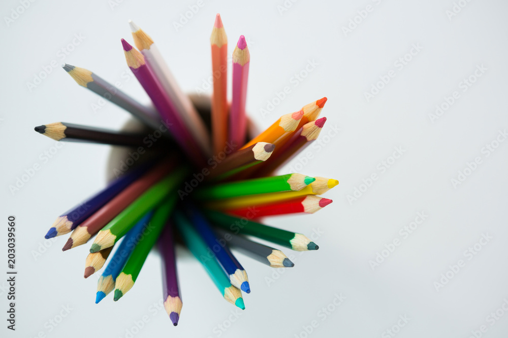 Colored pencils kept in mug on white background