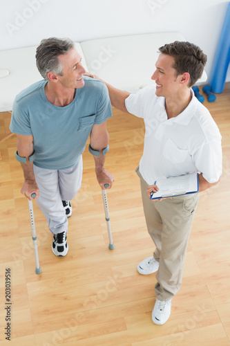Male therapist and disabled patient with reports