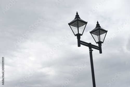 Lamppost with two lights against a blue sky with copy space 