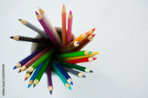 Colored pencils kept in mug on white background