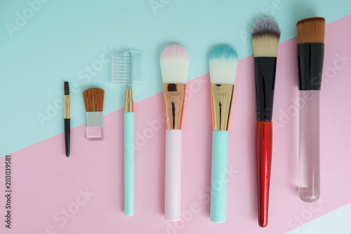 Flat lay creative concept of female decorative for many type of cosmetic cheek brush on the colorful background with copy space