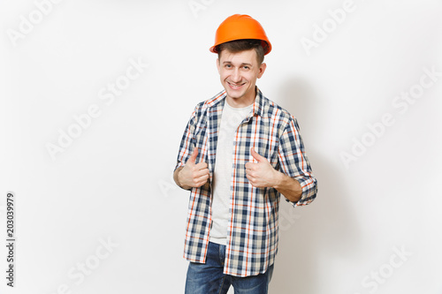 Young smiling handsome man in casual clothes and protective construction orange helmet showing thumbs up isolated on white background. Accessories for renovation apartment room. Repair home concept.