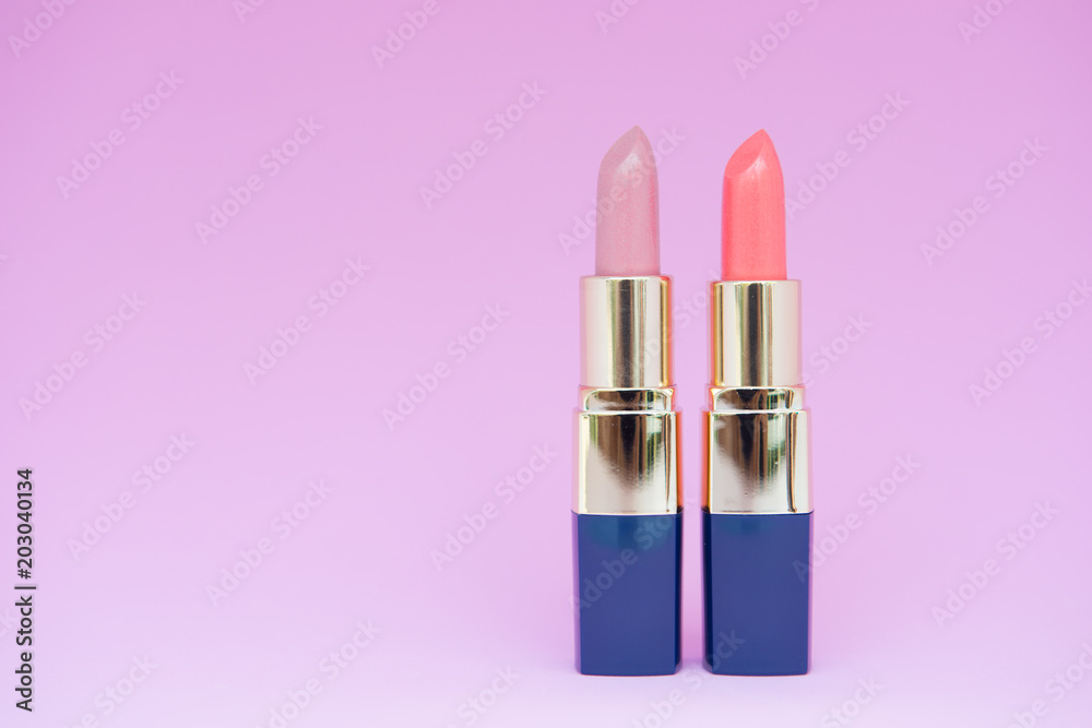 Minimal concept of creative female cosmetic for pink and orange lipstick on the colorful background with copy space Minimal concept of creative female cosmetic for pink and orange lipstick on the colorful background with copy space