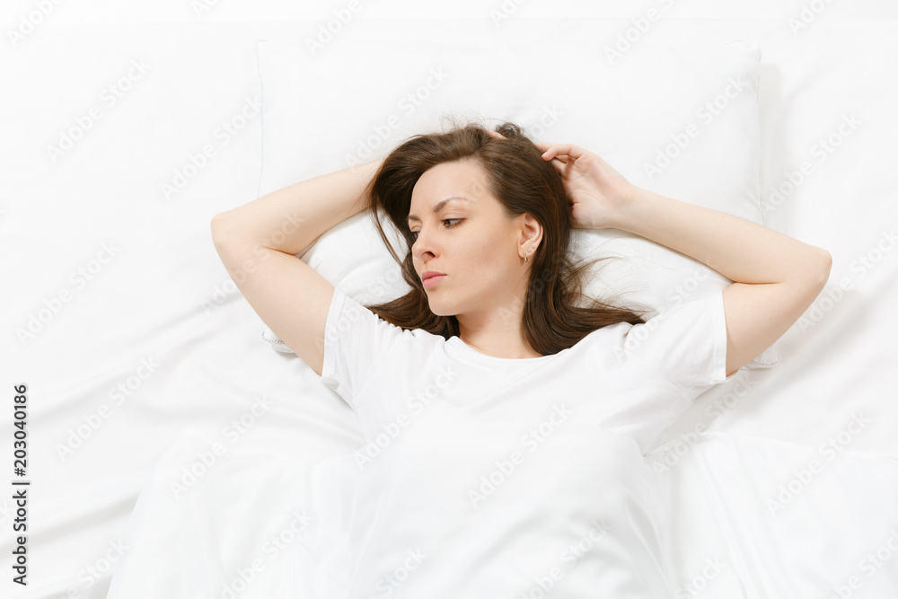 Top view of beautiful young woman lying in bed with white sheet, pillow, blanket. Calm pretty female looking aside, spending time in room. Rest, relax, good mood concept. Copy space for advertisement. Top view of beautiful young woman lying in bed with white sheet, pillow, blanket. Calm pretty female looking aside, spending time in room. Rest, relax, good mood concept. Copy space for advertisement.