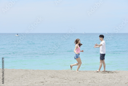 ビーチで恋人に駆け寄るカップル © ＭＯＭＯＴＡＲＯＵ