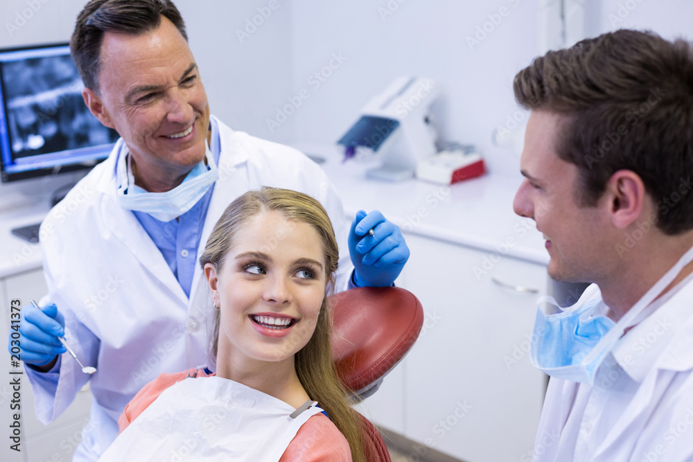 Dentists interacting with female patient Dentists interacting with female patient