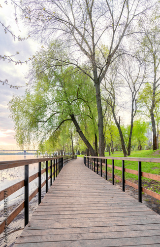 Footbridge, close to the Dnieper river, in the Natalka park in Kiev, Ukraine, during a cloudy spring morning © Maxal Tamor