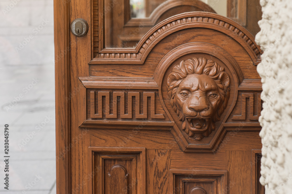 Big wooden head of lion on the front door Big wooden head of lion on the front door