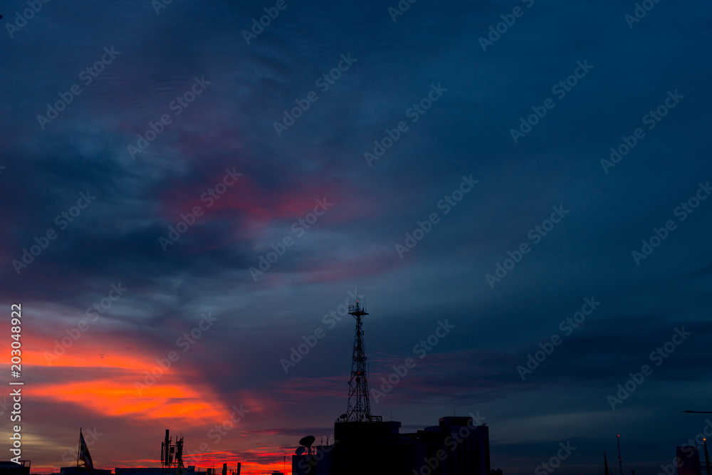 Silhouette of cellular tower with beautiful sunset cloudy sky