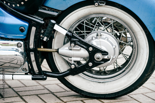 Motorcycle wheel with disk brakes system and metal spokes. Closeup detailed photo of motorbike forks and tire. Different parts of two-wheeled vehicle. Transportation. Modern driving technologies.