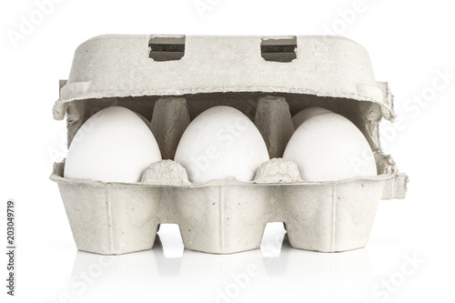 Six white chicken eggs in a paper grey crate isolated on white background front view.