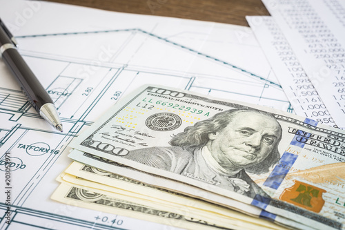 Dollar money budget and blueprint plan on table.