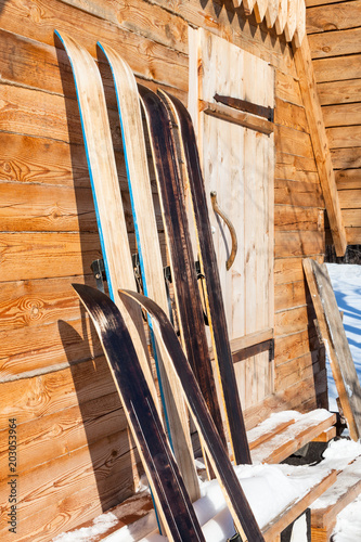 wide hunting skis near wall of wooden cottage